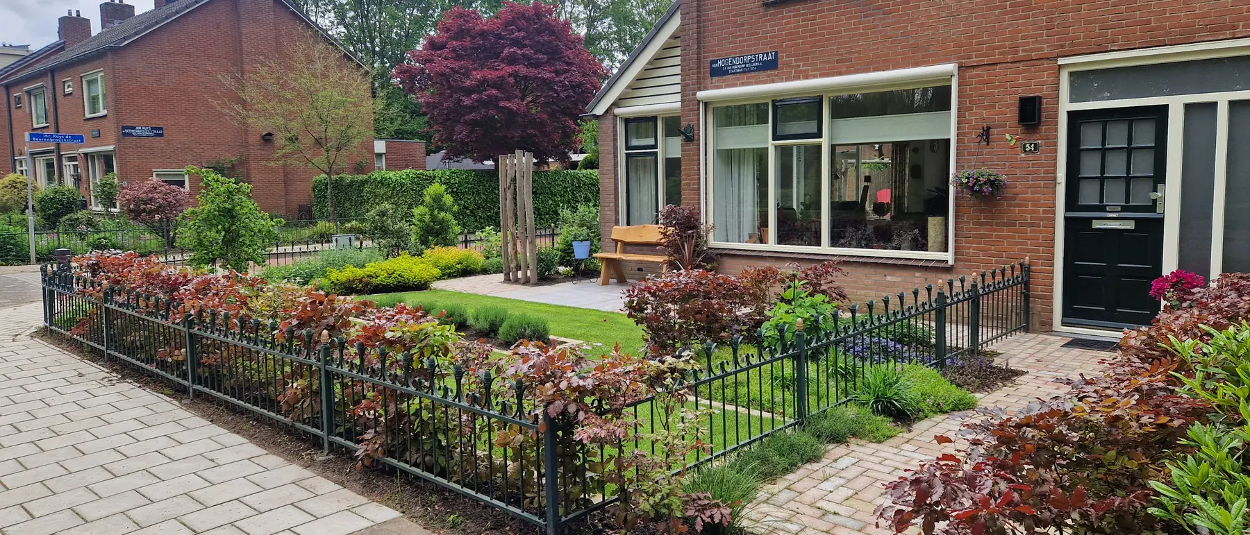 Voortuin met borders en gebakken bestrating, aangelegd door Paul Coenen