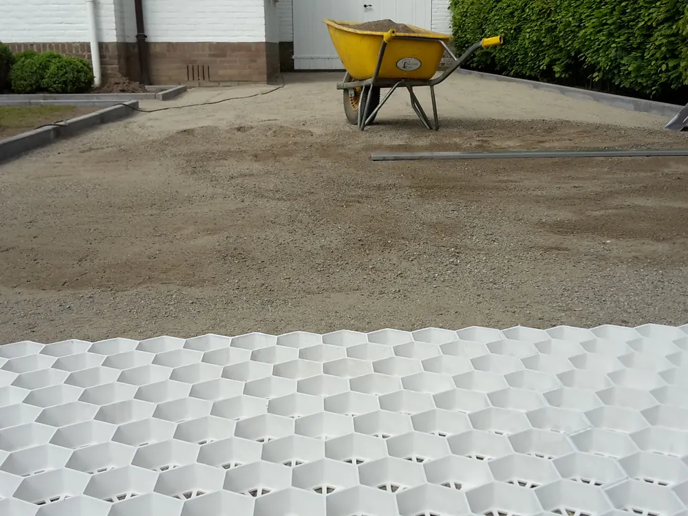 Aanleg van bestrating met grindkoffer en waterpas gelegde tegels