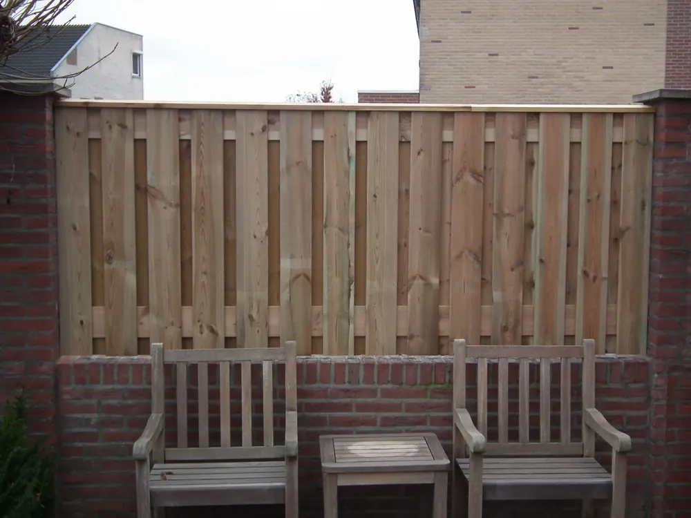 Houten schutting op betonnen poeren als erfafscheiding